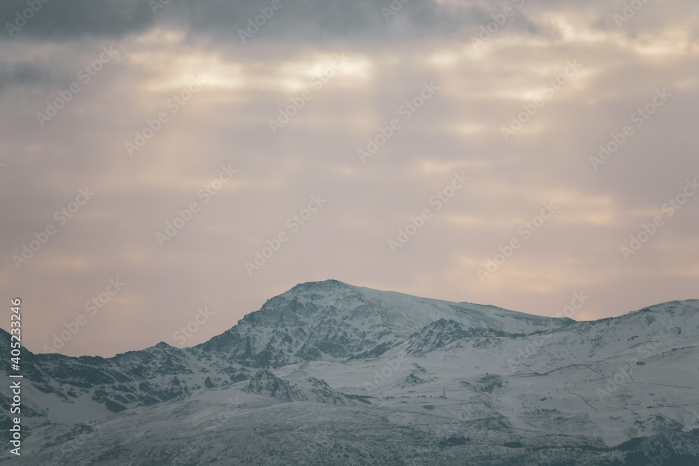 View of the highest peaks of Sierra Nevada (Granada, Spain) on a cloudy winter morning at sunrise