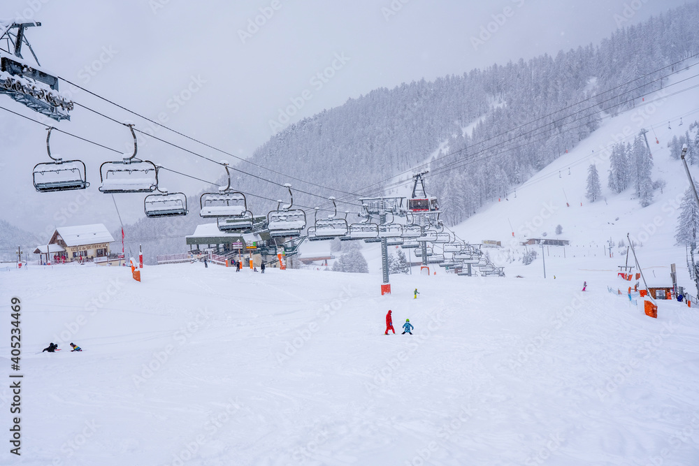Winter snowing day on a ski resort. Downhill skiing during a heavy snowfall. Ski race for young children. Blurred focus background. High quality photo Winter snowing day on a ski resort. Downhill skiing during a heavy snowfall. Ski race for young children. Blurred focus background. High quality photo