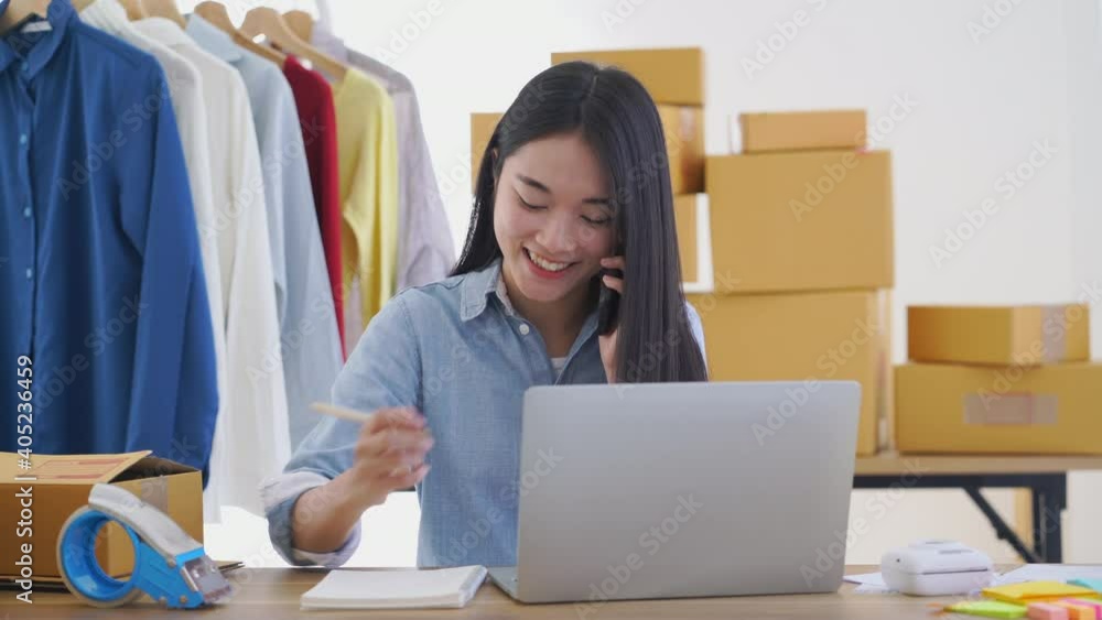 woman online entrepreneur talking on a smartphone and using laptop computer to selling product online at home office woman online entrepreneur talking on a smartphone and using laptop computer to selling product online at home office