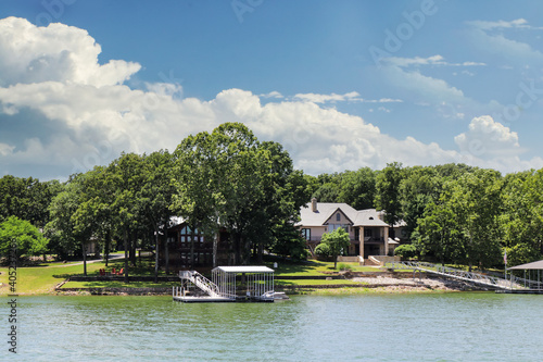 Luxury houses built beside lake with docks and little beaches among the trees