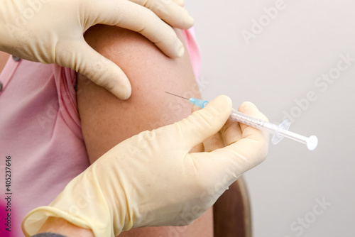 Eine Patientin erhält eine Impfdosis in die Schulter - Coronaimpfung photo