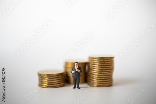 Business, Money Investment and Planning Concept. Fat businessman miniature figure people figure standing with stack of gold coins with copy sapce.