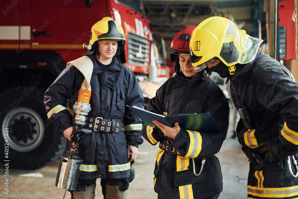 With notepad. Group of firefighters in protective uniform that is on station With notepad. Group of firefighters in protective uniform that is on station