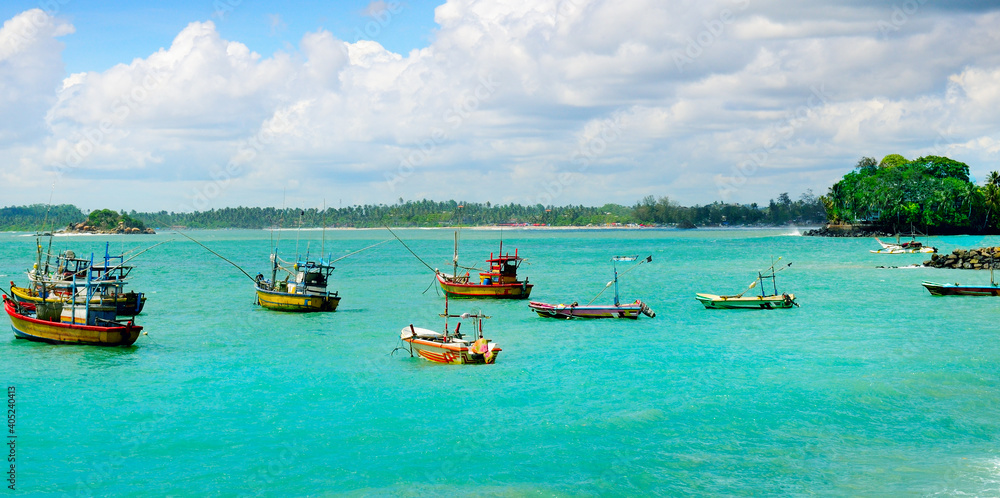 Traditional wooden fishing boats in the ocean. Wide photo.