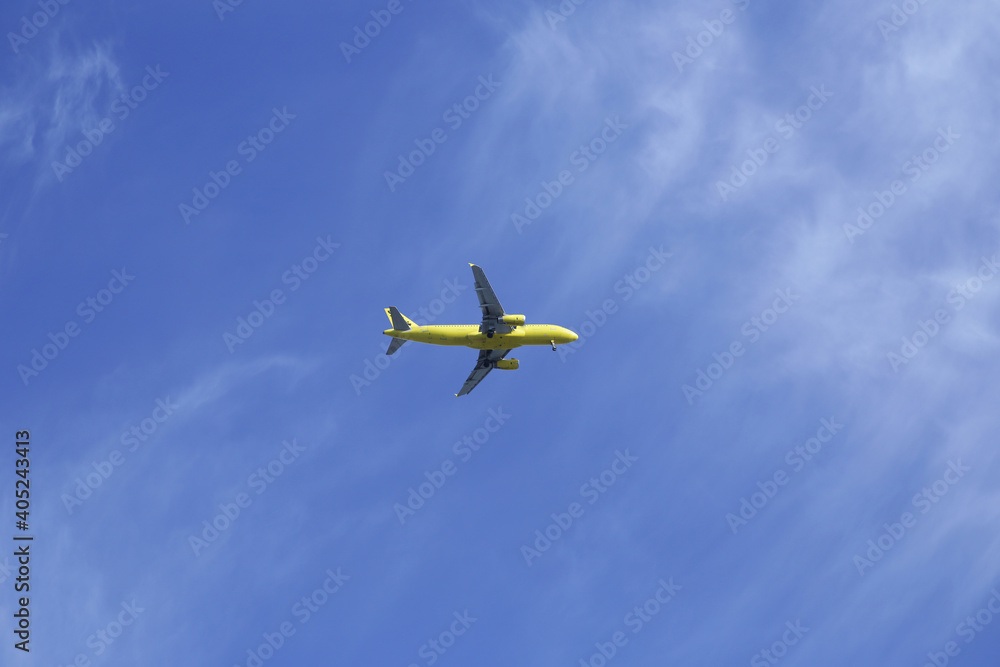 passenger yellow plane with landing gear down in blue sky with copy space for text and image passenger yellow plane with landing gear down in blue sky with copy space for text and image