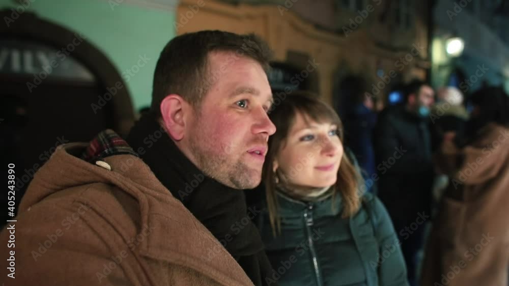 A man and a woman are talking near the store. Showcase illuminates faces. Choice of shopping in the night city. Exchanging verbal messages on a date. A man and a woman are talking near the store. Showcase illuminates faces. Choice of shopping in the night city. Exchanging verbal messages on a date.