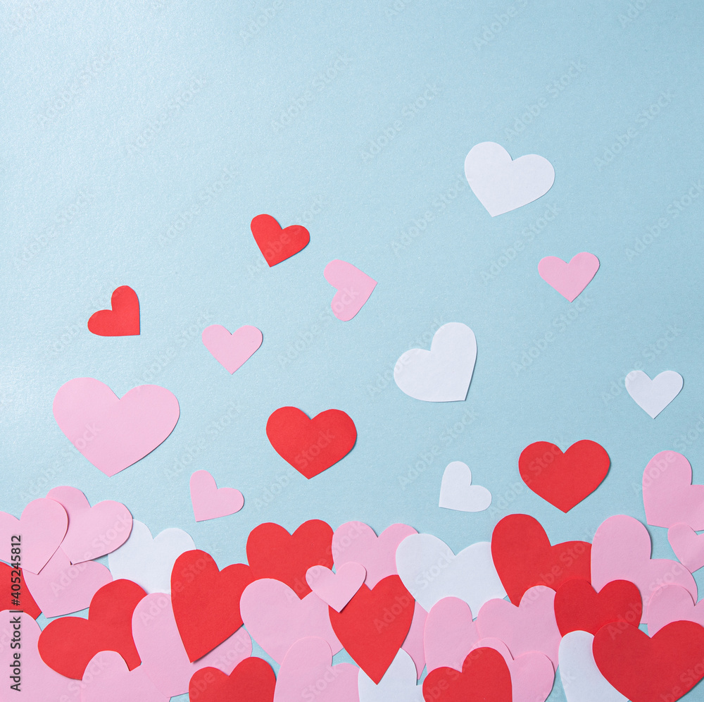 Flat lay with red, pink and white hearts on pastel blue background. The concept of Valentine's Day