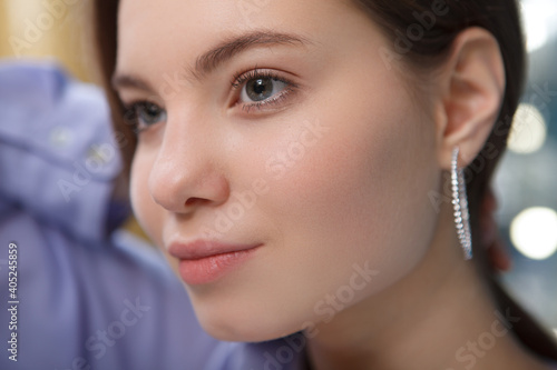 Close up of a beautiful woman wearing diamond hoop earring, looking away