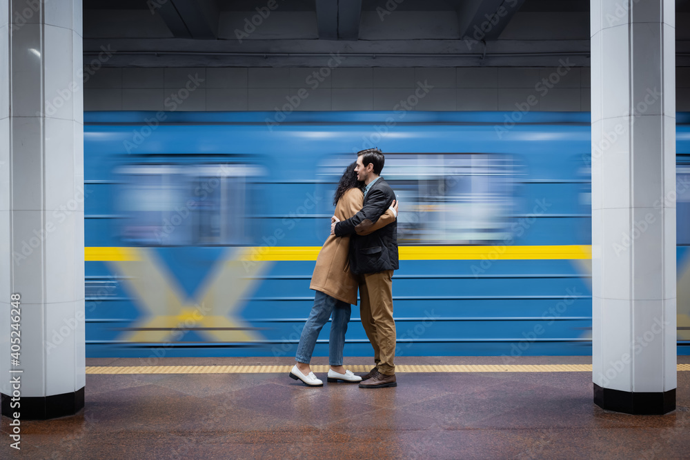 Fototapeta premium motion blur of interactional couple hugging near wagon in subway