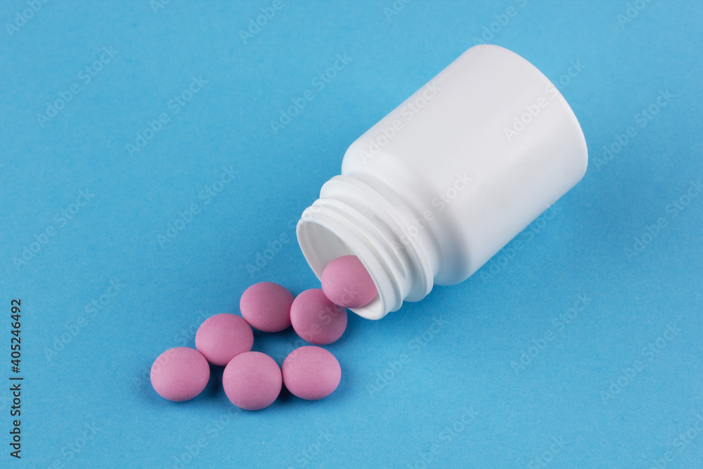 pink tablets poured out of a white bottle