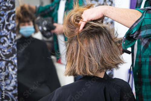 hairdresser stylist drying and styling wet hair