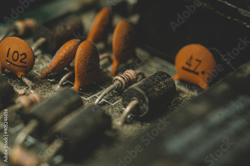 A group of dusty electronic components. Focus on the front of the resistor in the center of the frame photo