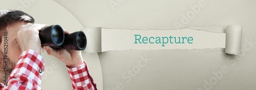 Recapture. Man (lawyer) observing with binoculars. Focus on text/word on a ripped paper. photo