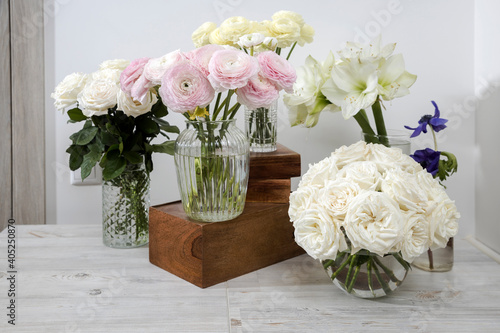 Wallpaper Mural White roses, ranunculus, blue anemones, yellowish buttercups, lilies in round vases on the wooden boxes on the table for a special occasion as a kitchen decoration. Torontodigital.ca