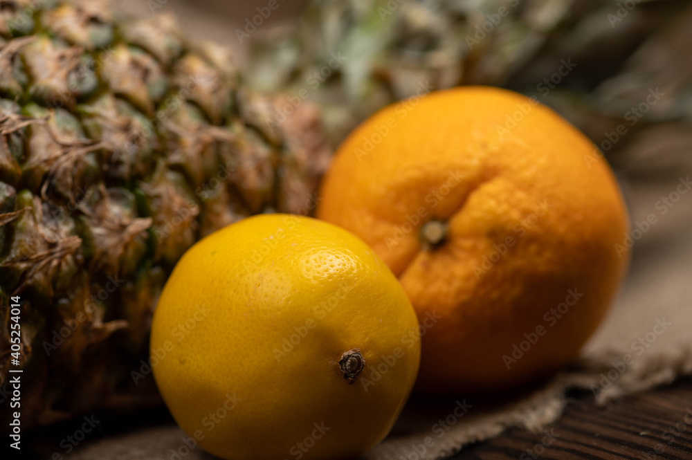 Ripe pineapple, lemon and orange. Close-up, selective focus.