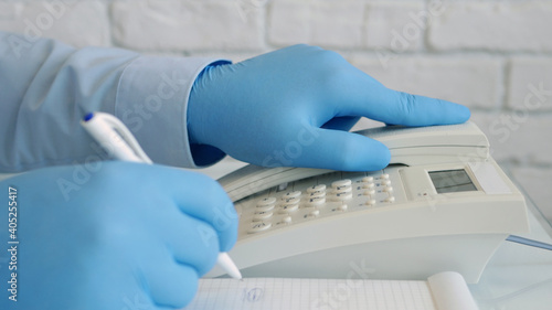 Image with Businessman Hands Wearing Protective Gloves Using Telephone