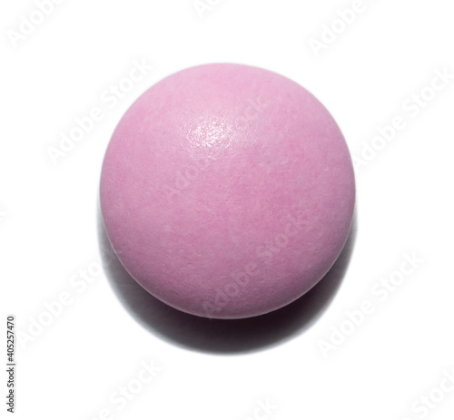 Pink pill on an isolated background. Medicine and vitamin for disease and disease prevention.