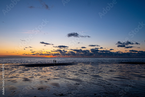 View of the setting sun shining on the Sea and reflected on the beach, clouds with sun-shining edges. Landscape. High quality photo showing concept of freedom and dreams © Bjorn B