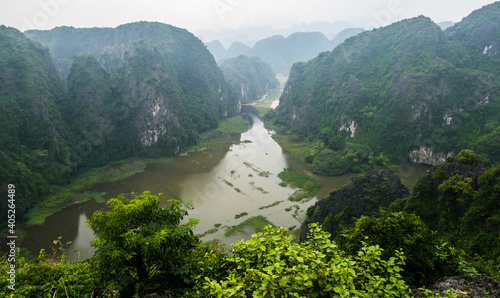 A misty view of mountains surrounded by water in Ninh Binh, Vietnam
