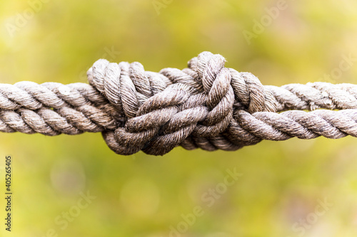 Selective focus of knotted ropes on blurred green background