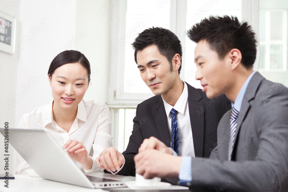 Group of businesspeople discussing working on computer Group of businesspeople discussing working on computer