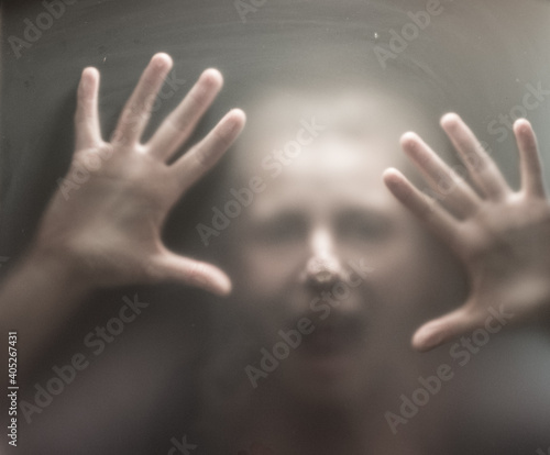 Fototapeta Naklejka Na Ścianę i Meble -  Scary picture of hands behind glass.