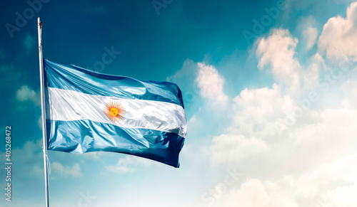 Argentine flag, light blue and white, waving in the wind with a blue sky with clouds