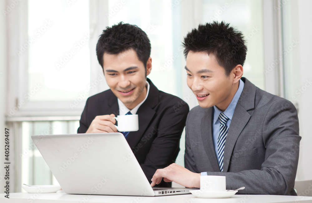 Group of businesspeople discussing working on computer Group of businesspeople discussing working on computer