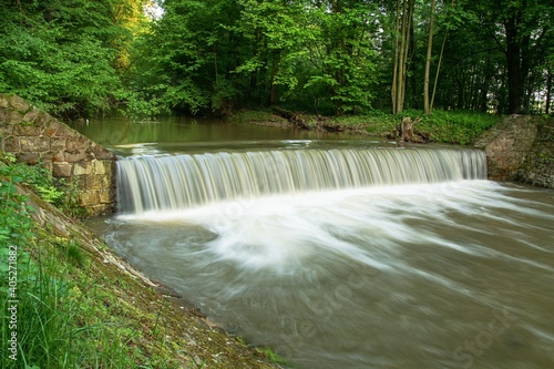 Weir on the river. Water whirlpools behind it. River Juhyne. East Moravia. Czech Republic. Europe.