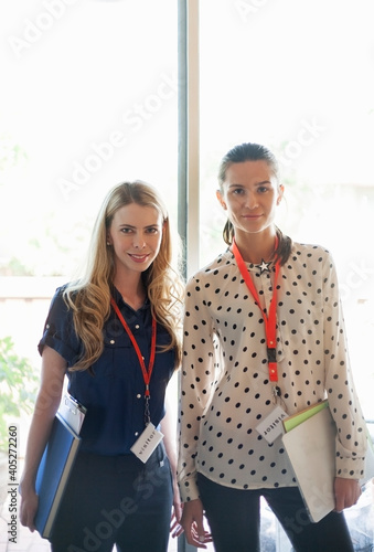 Confident entrepreneur wearing Visitor lanyard standing at office