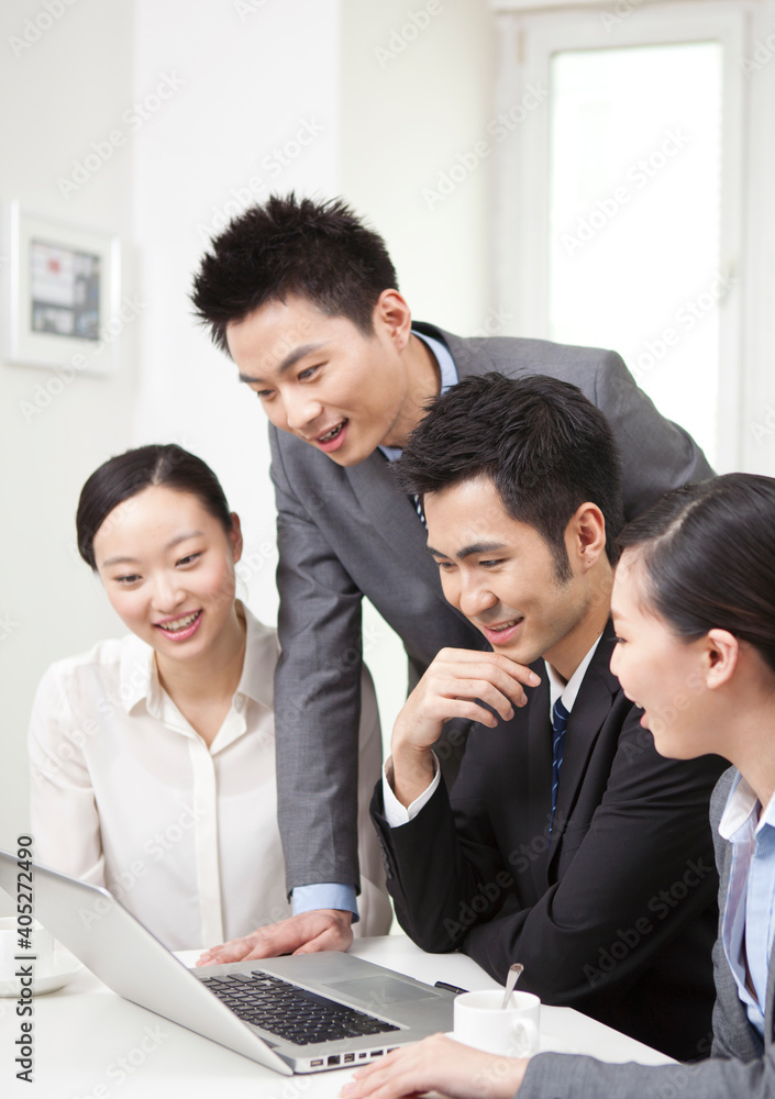 Group of businesspeople discussing working on computer Group of businesspeople discussing working on computer