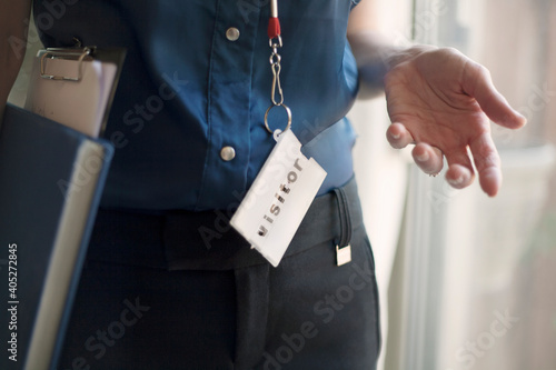 Businesswoman wearing Visitor lanyard standing at office