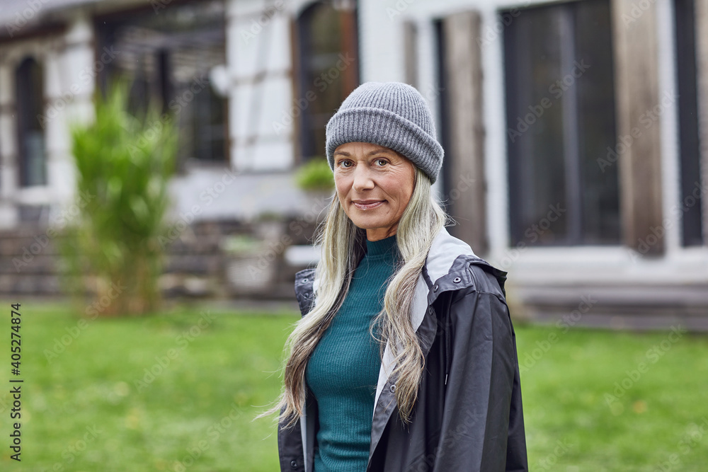 Confident mature woman wearing knit hat in back yard Confident mature woman wearing knit hat in back yard