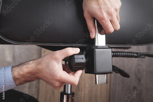 Φωτογραφία Male hands adjusts office chair.