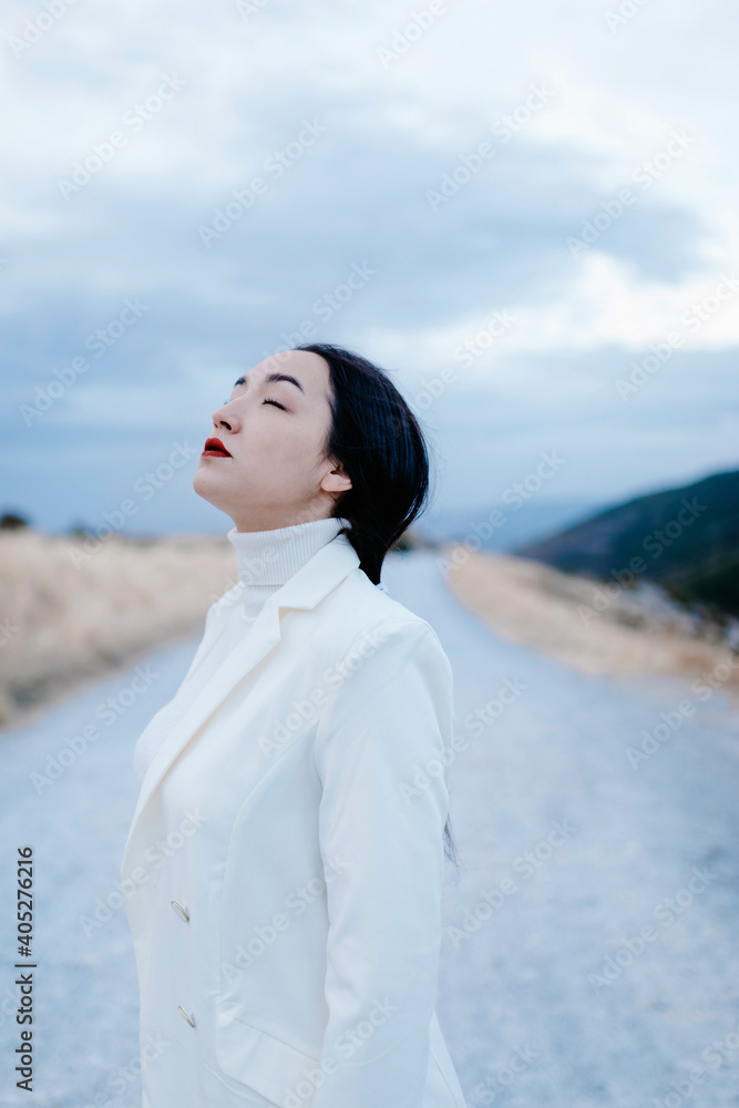 Young woman with eyes closed standing on road Young woman with eyes closed standing on road
