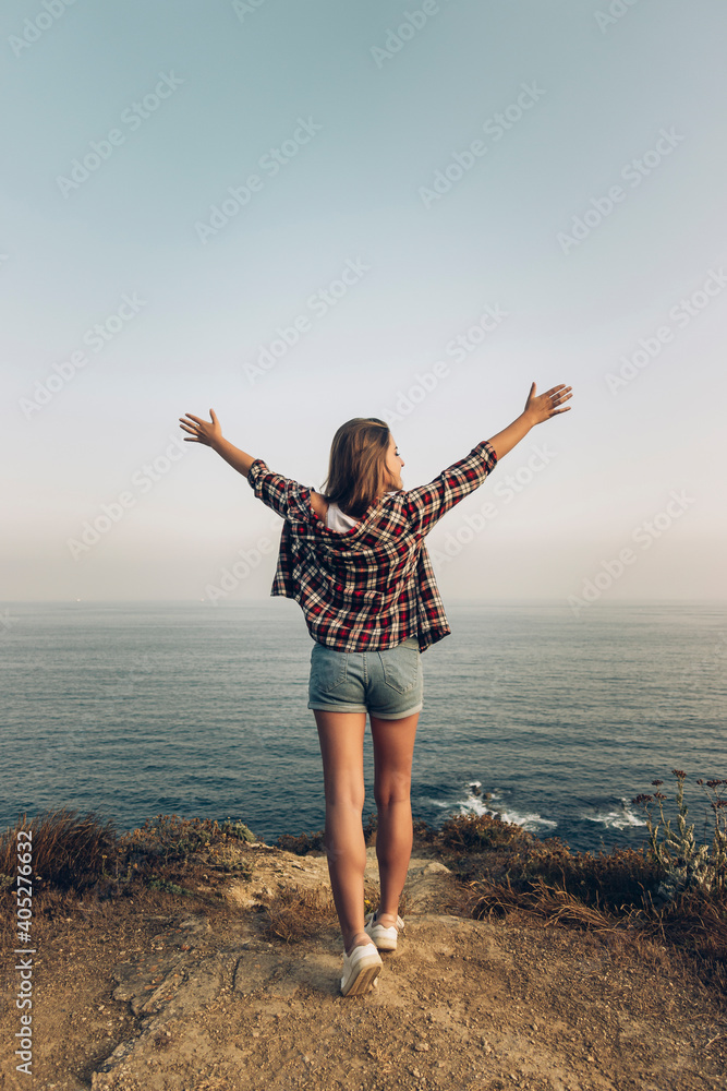 Young woman with arms outstretched standing against clear sky Young woman with arms outstretched standing against clear sky