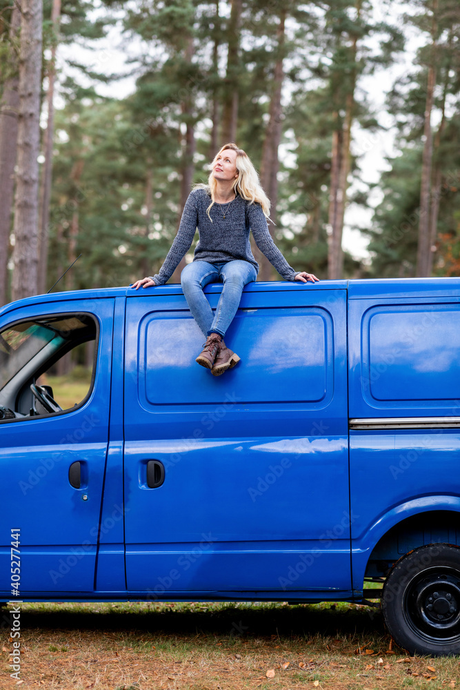 Woman with blond hair looking up while sitting on top of motor home at Cannock Chase Woman with blond hair looking up while sitting on top of motor home at Cannock Chase