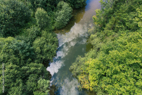 rivière avec le reflet du ciel et arbres vus d'un drone 