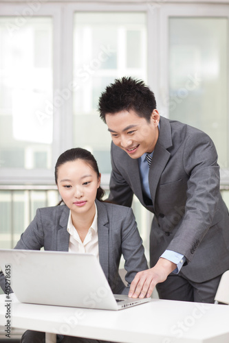 Business man and business woman working on computer