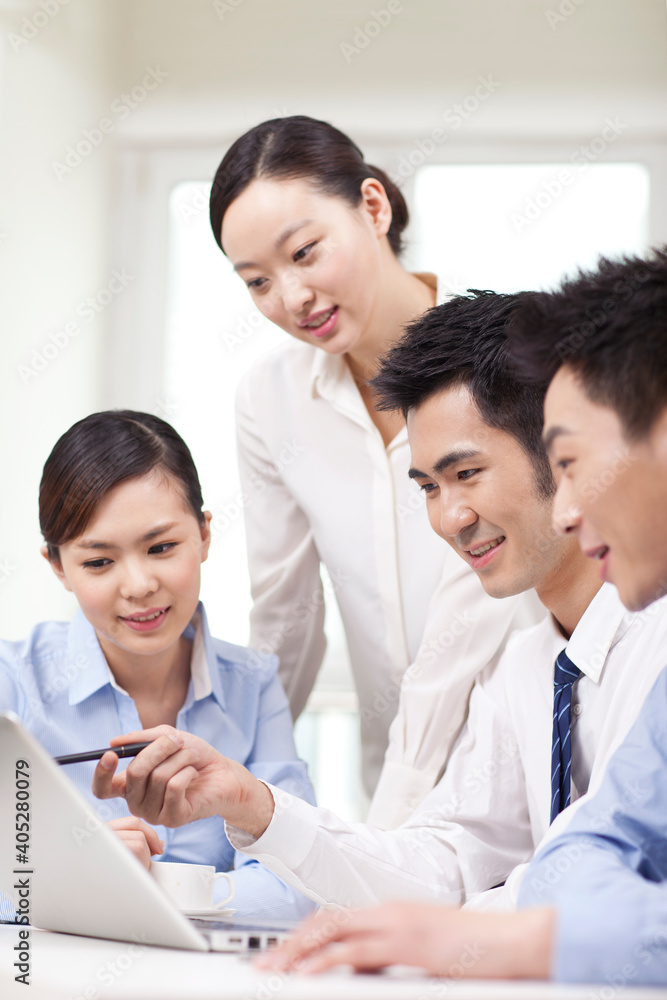 Group of businesspeople discussing working on computer Group of businesspeople discussing working on computer