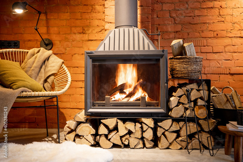 Valokuvatapetti Cozy fireplace with firewood in the loft style home interior with brick wall bac
