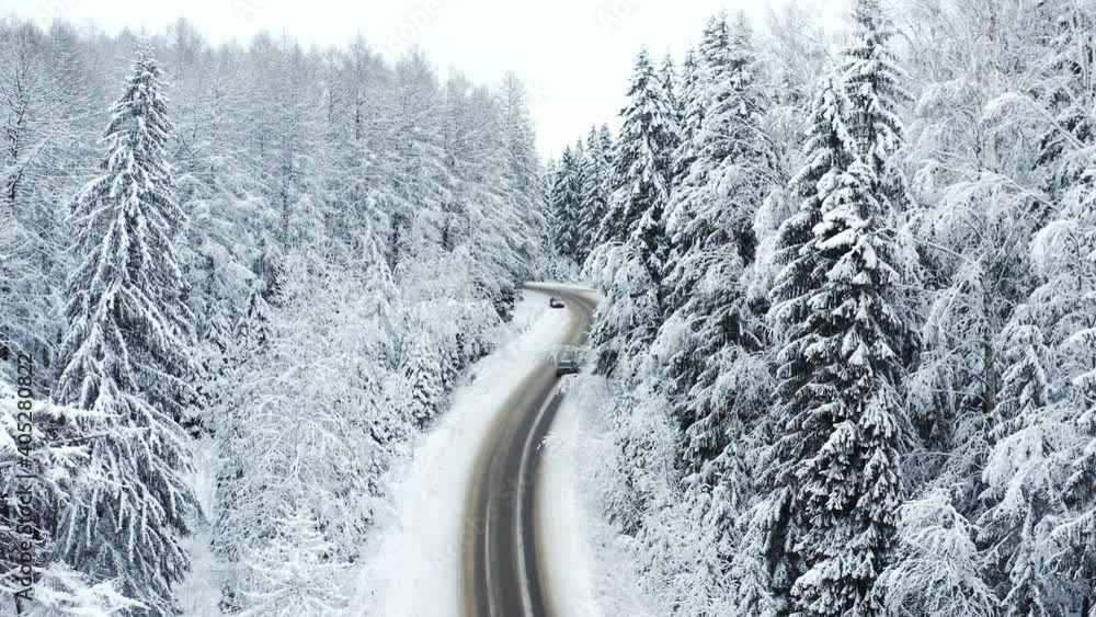 Car driving on winter country road in snowy forest, aerial view from drone in 4k. Car driving on winter country road in snowy forest, aerial view from drone in 4k.