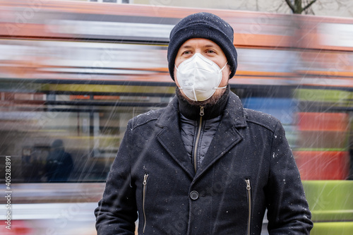 Mann mit FFP2 Maske wegen Corona Maskenpflicht im öffentlichen Nahverkehr in Deutschland Sachsen Dresden vor Haltestelle Dresdner Verkehrsbetriebe DVB photo