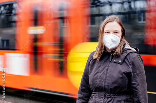 Frau mit FFP2 Maske wegen verschärfter Corona Maskenpflicht im öffentlichen Nahverkehr in Deutschland Sachsen Dresden vor Haltestelle Dresdner Verkehrsbetriebe DVB photo