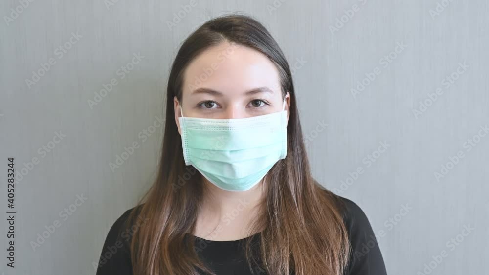 Pretty Woman putting on surgical mask looking at camera smile coronavirus Covid-19 pandemic is over. Pretty Woman putting on surgical mask looking at camera smile coronavirus Covid-19 pandemic is over.