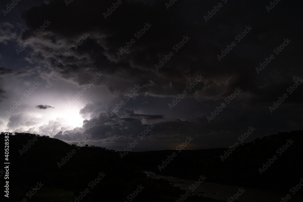 Strong lightning in and behind big towering thunderclouds Strong lightning in and behind big towering thunderclouds