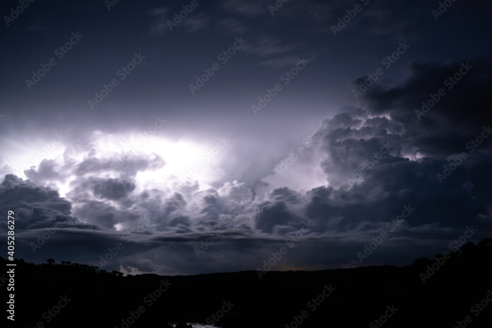 Strong lightning in and behind big towering thunderclouds Strong lightning in and behind big towering thunderclouds