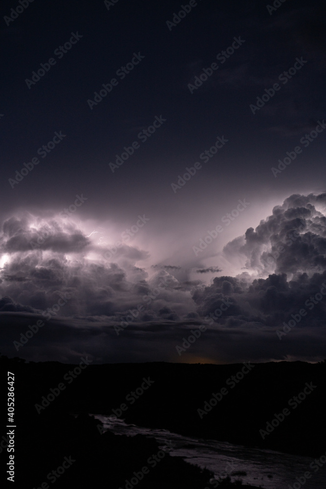 Strong lightning in and behind big towering thunderclouds Strong lightning in and behind big towering thunderclouds