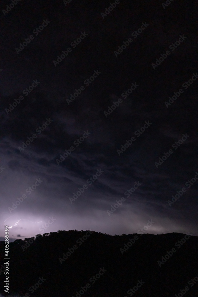 Strong lightning in and behind big towering thunderclouds Strong lightning in and behind big towering thunderclouds