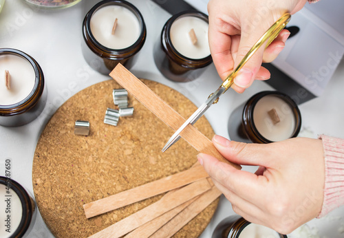 Cutting the wick out of handmade soy candles. Amber and opaque container. Candle making utensils. Cruelty-free vegan product